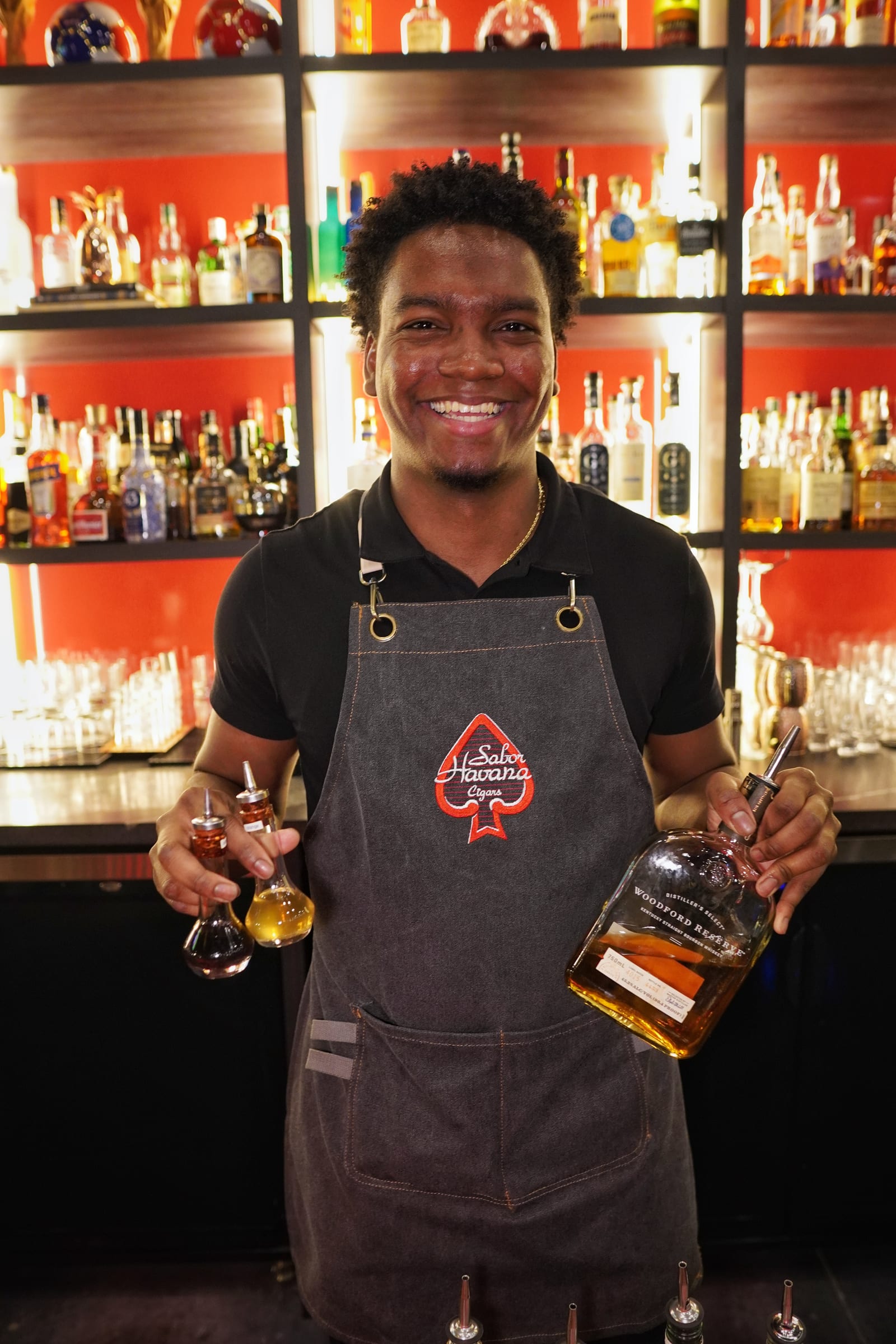 Bartender with whiskey bottles at the Sabor Havana bar in Doral, Miami